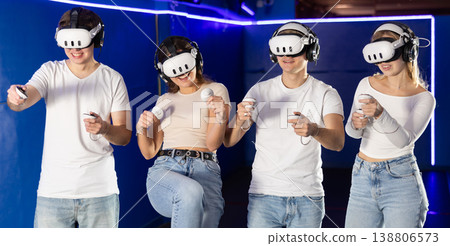 Friends playing video games in virtual reality headsets Friends playing video games in virtual reality headsets 138806573