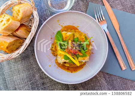 Fried pollock fillet with quinoa, curry and vegetables 138806582