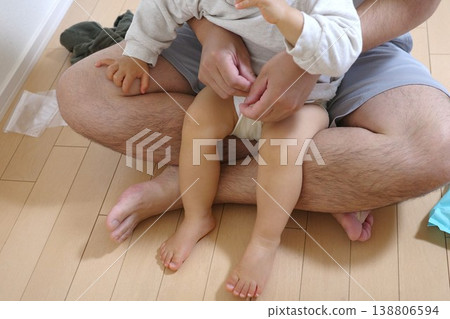 Dad sitting at home changing the baby's diaper 138806594