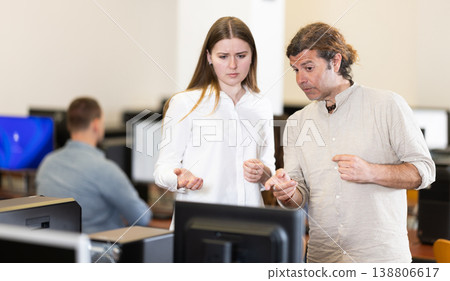 Man and young woman discussing at computer 138806617