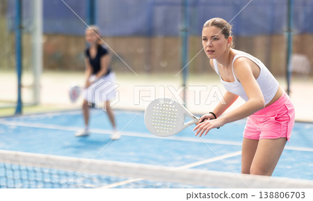 Woman standing behind net on tennis court Woman standing behind net on tennis court 138806703