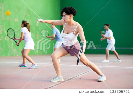 Woman pelota player hitting ball with racket Woman pelota player hitting ball with racket 138806761