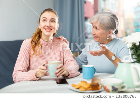 Senior mother and adult granddaughter having conversation and drinking tea 138806763