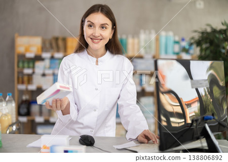 Young female pharmacist offering preparation in box Young female pharmacist offering preparation in box 138806892