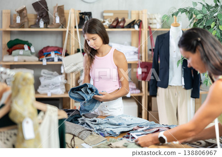 Mother and teenage daughter choosing jean shorts in clothing store Mother and teenage daughter choosing jean shorts in clothing store 138806967