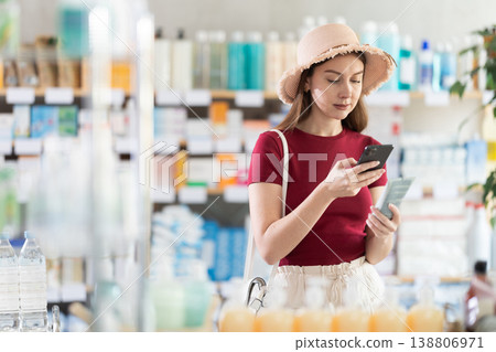 Woman scanning sunscreen packaging Woman scanning sunscreen packaging 138806971