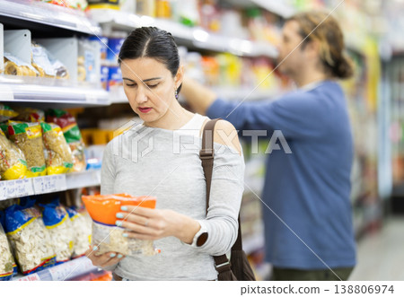 Woman in supermarket choose groats Woman in supermarket choose groats 138806974