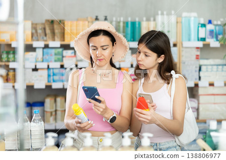 Mom and daughter scan repellents on phone 138806977