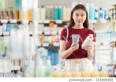 Young woman buyer select cream in drug store Young woman buyer select cream in drug store 138806988