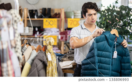 In chain shop, guy choose down jacket In chain shop, guy choose down jacket 138806993