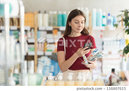 Woman in pharmacy scans QR code on toothbrush Woman in pharmacy scans QR code on toothbrush 138807015
