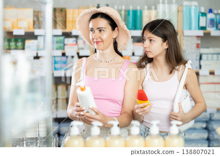 Mom and daughter choosing sunscreen in chemist's shop 138807021