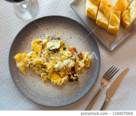 Delicious breakfast in cafe of scramble eggs with pork pieces closeup Delicious breakfast in cafe of scramble eggs with pork pieces closeup 138807068