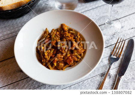 Dish of green beans with ham and tomatoes 138807082