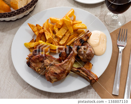 Grilled lamb rib chop steaks, medium rare with french fries on plate Grilled lamb rib chop steaks, medium rare with french fries on plate 138807110