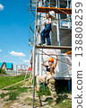 Two women in hard hats standing on scaffolding at a residential construction site, safety and teamwork concept 138808259
