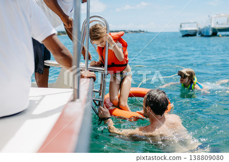 Family swimming and snorkeling near boat during tropical vacation. Family swimming and snorkeling near boat during tropical vacation. 138809080