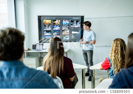 Teen boy presenting school project in front of classroom. 138809303