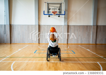 Wheelchair basketball player shooting ball towards hoop. Wheelchair basketball player shooting ball towards hoop. 138809331