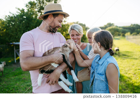 Family petting little goat at farm. 138809416