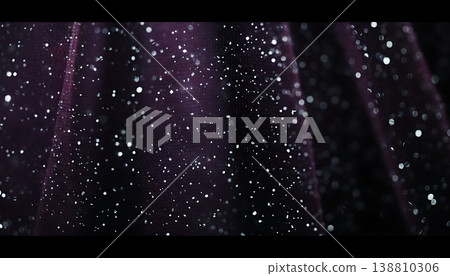 Close-up view of shimmering silver glitter particles scattered on a dark purple fabric background, creating a textured and visually striking surface 138810306