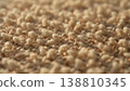 Close-up view of textured beige fabric with soft fibers and subtle golden threads, showcasing intricate weaving patterns and a warm, inviting appearance 138810345
