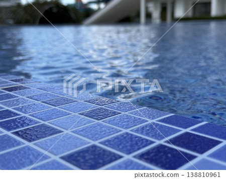 Swimming pool with blue tile edge and rippled water surface, perfect for a summer background 138810961