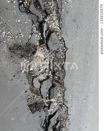Damaged asphalt road surface with cracks creating rugged pattern and texture 138810979
