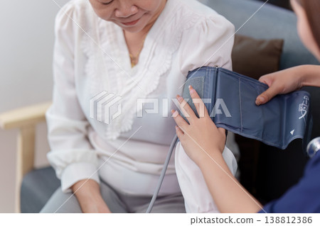 Nurse measuring blood pressure of elderly woman 138812386