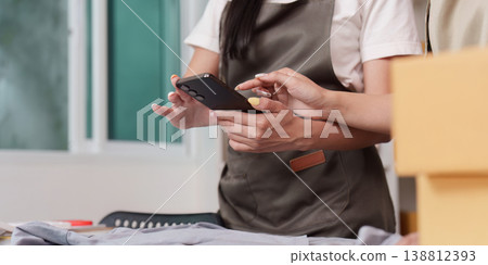 Entrepreneurs using smartphone for online store tasks 138812393