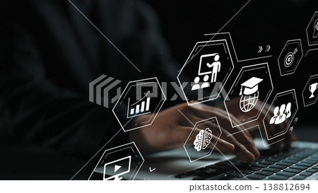 Hands Typing on a Laptop with Digital Icons Representing Education, Business, and Technology in a Dark Setting Gluon 138812694