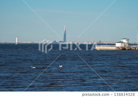 Clear blue sky overlooks calm water. Lakhta Center in St. Petersburg Clear blue sky overlooks calm water. Lakhta Center in St. Petersburg 138814328