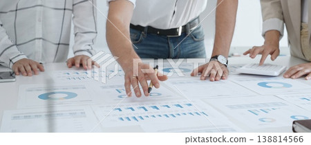Professional team reviewing financial charts, working together in contemporary workspace, brainstorming strategic improvements. Business people concept Professional team reviewing financial charts, working together in contemporary workspace, brainstorming strategic improvements. Business people concept 138814566