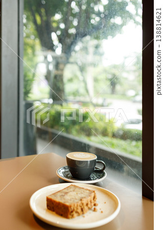 Cup of hot milk latte coffee on table by the window. 138814621