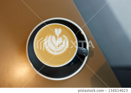 Cup of hot milk latte coffee on table by the window. Cup of hot milk latte coffee on table by the window. 138814623