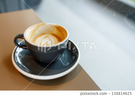 Cup of hot milk latte coffee on table by the window. Cup of hot milk latte coffee on table by the window. 138814625