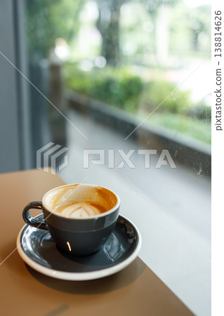 Cup of hot milk latte coffee on table by the window. Cup of hot milk latte coffee on table by the window. 138814626