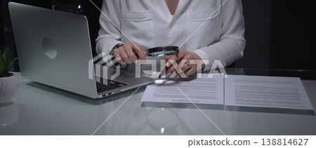 Woman analyzing contract text with magnifying glass, scrutinizing fine print for legal details and agreement review. Audit, business and overworking concepts Woman analyzing contract text with magnifying glass, scrutinizing fine print for legal details and agreement review. Audit, business and overworking concepts 138814627