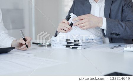 Business people preparing financial documents and signing reports at office desk, analyzing taxation data. Audit and taxes in business Business people preparing financial documents and signing reports at office desk, analyzing taxation data. Audit and taxes in business 138814649