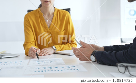 Business professionals gathered around conference table, reviewing financial charts, collaborating on strategic planning and corporate analysis Business professionals gathered around conference table, reviewing financial charts, collaborating on strategic planning and corporate analysis 138814725