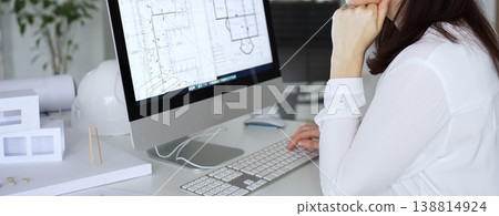 Woman architect analyzing construction blueprint on computer screen in modern design office, planning new building project. Business and architecture concept Woman architect analyzing construction blueprint on computer screen in modern design office, planning new building project. Business and architecture concept 138814924