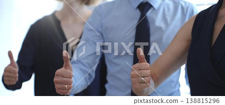 Business people team showing thumbs up gestures in a row, expressing approval, agreement, success, and full support for a project or strategy in a corporate office setting with sun flair Business people team showing thumbs up gestures in a row, expressing approval, agreement, success, and full support for a project or strategy in a corporate office setting with sun flair 138815296