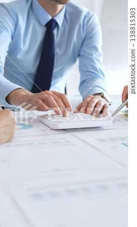 Business people team meeting with charts and documents on desk discussing financial strategy, planning corporate growth, analyzing market data and performance reports 138815303