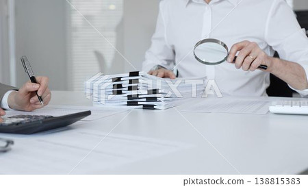 Auditors and financial experts analyzing tax documents, reviewing contract papers, and calculating data for investigation. Audit and taxes in business 138815383