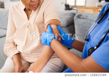 Senior woman, nurse and plaster for arm vaccine, medical and healthcare treatment for virus safety, flu and wellness. Patient, elderly person or doctor hands with injection bandage in retirement home 138815384