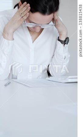 Stressed businesswoman suffering headache and pain, feeling overworked during office hours, facing deadlines and pressure. Audit and taxes in business Stressed businesswoman suffering headache and pain, feeling overworked during office hours, facing deadlines and pressure. Audit and taxes in business 138815438