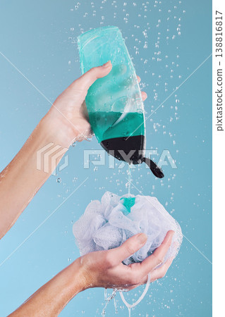 Woman, hands and loofah with soap in shower for hygiene, washing or cleaning body against a blue studio background. Closeup of female person pouring gel bottle with falling water or rain on sponge Woman, hands and loofah with soap in shower for hygiene, washing or cleaning body against a blue studio background. Closeup of female person pouring gel bottle with falling water or rain on sponge 138816817