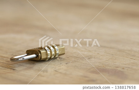 Combination brass padlock on wooden surface for security and data protection concept 138817658