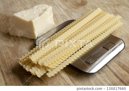 Dry lasagna pasta on digital kitchen scale with parmesan cheese 138817660