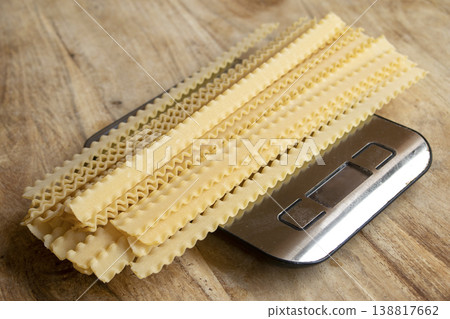 Dry mafaldine pasta on digital kitchen scale for portion control Dry mafaldine pasta on digital kitchen scale for portion control 138817662